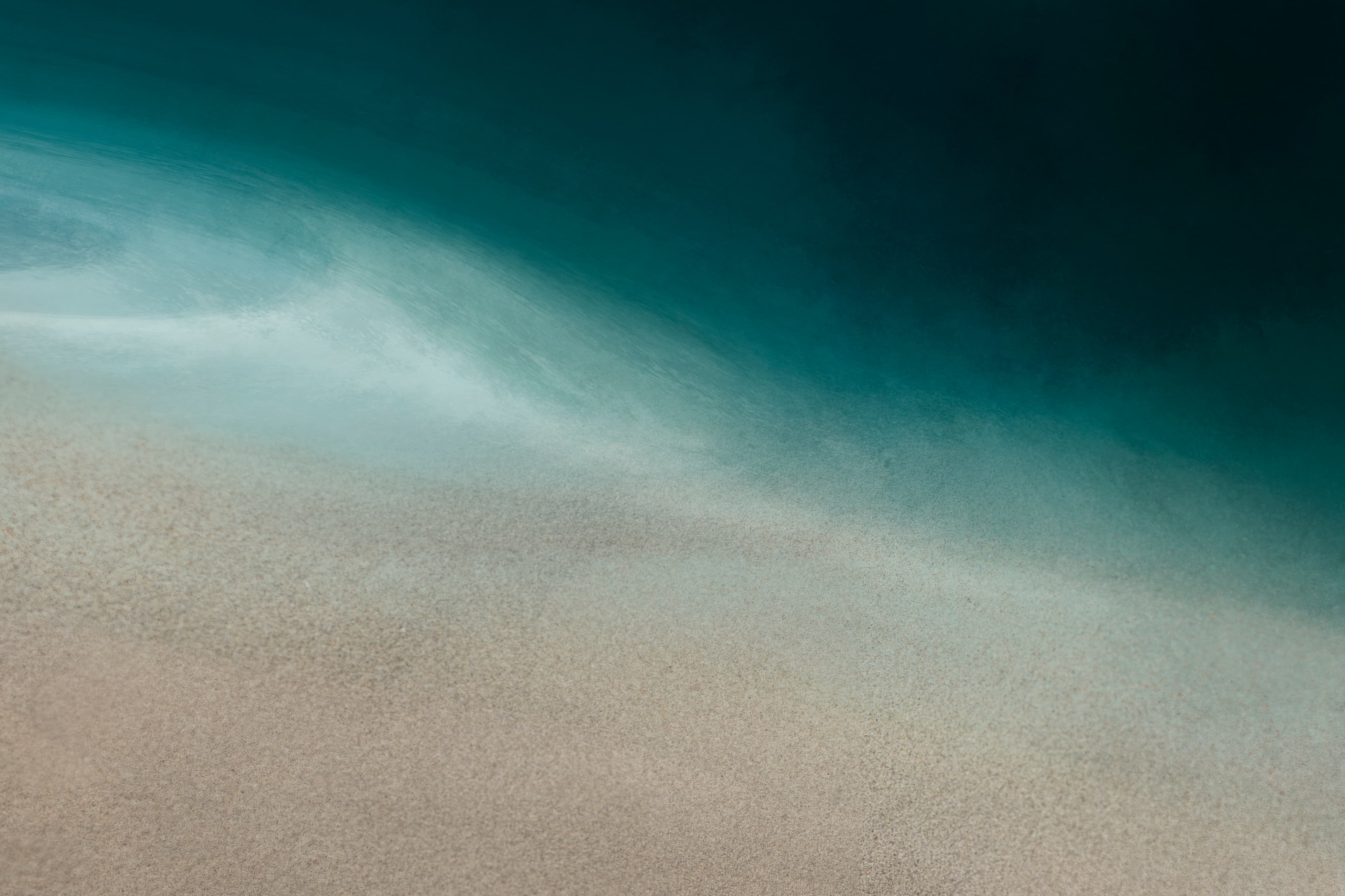 Textura suave de arena y mar en tonos azul profundo.